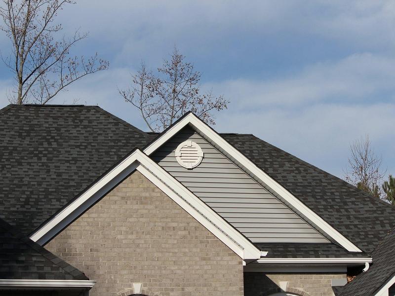 Example photo: dark gray asphalt shingle roof on a brick and siding house